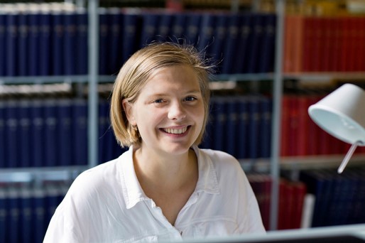 Female student in front of bookshelf